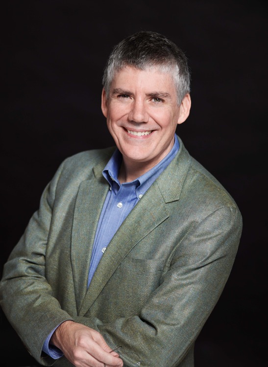 Rick Riordan wearing a green blazer and blue shirt