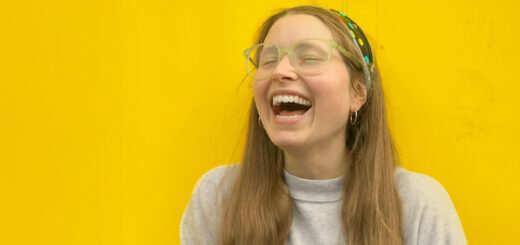 Jessie Cave poses in front of a yellow wall.