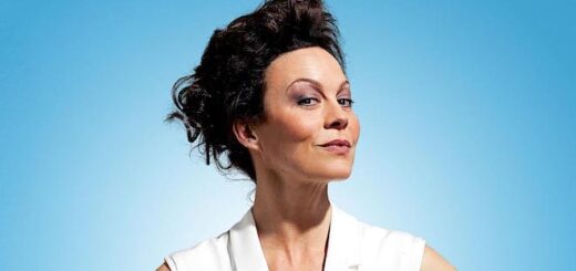 A picture of Helen McCrory. She is wearing a white outfit against a blue background and is facing the camera.