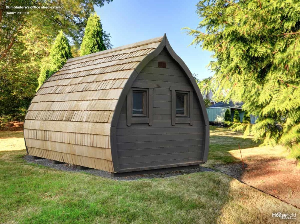 In a sunny garden, there is a designer shed pictured, with an upside-down drop shape. It is made of wood and looks like a fairy-tale cabin.