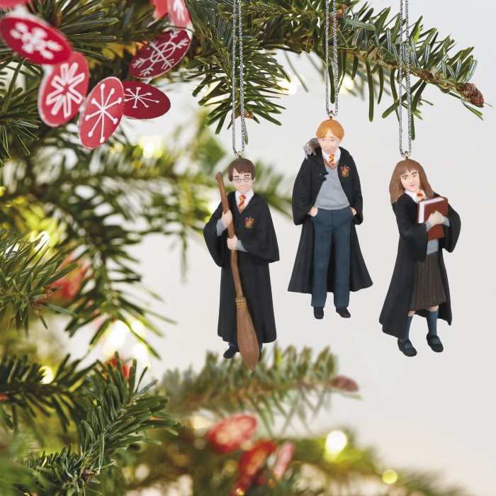 A branch of a Christmas tree is pictured with a set of miniature Harry, Ron, and Hermione ornaments hanging from it.