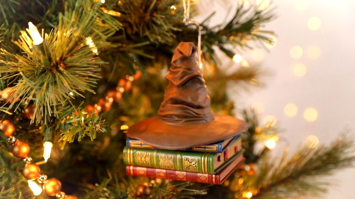 A sorting hat perched on books is pictured as an ornament on a Christmas tree.