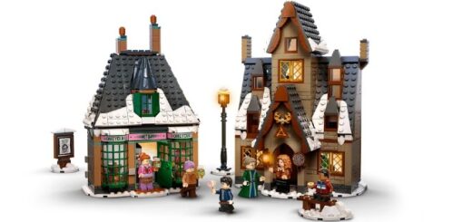 Against a white backgrop, there are two fabulous LEGO buildings fromt he shopfront side. On the left is Honeydukes Sweetshop and on the right is the Three Broomsticks inn. There are some characters from Harry Potter millin around, a streetlamp, a bench, and a wanted poster of Sirius Black.