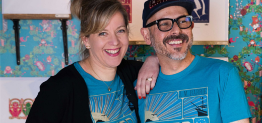 Miraphora Mina (left) and Eduardo Lima (right) of MinaLima are pictured wearing blue "Peter Pan" T-shirts from the MinaLima Classics apparel collaboration with Out of Print.