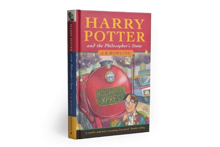 A hardback copy of the first edition of Harry Potter and the Philosopher's Stone is pictured against a white background.