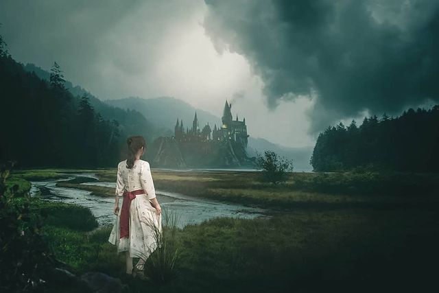 A fantasy photo depicts a young lady staring at Hogwarts, far in the distance 