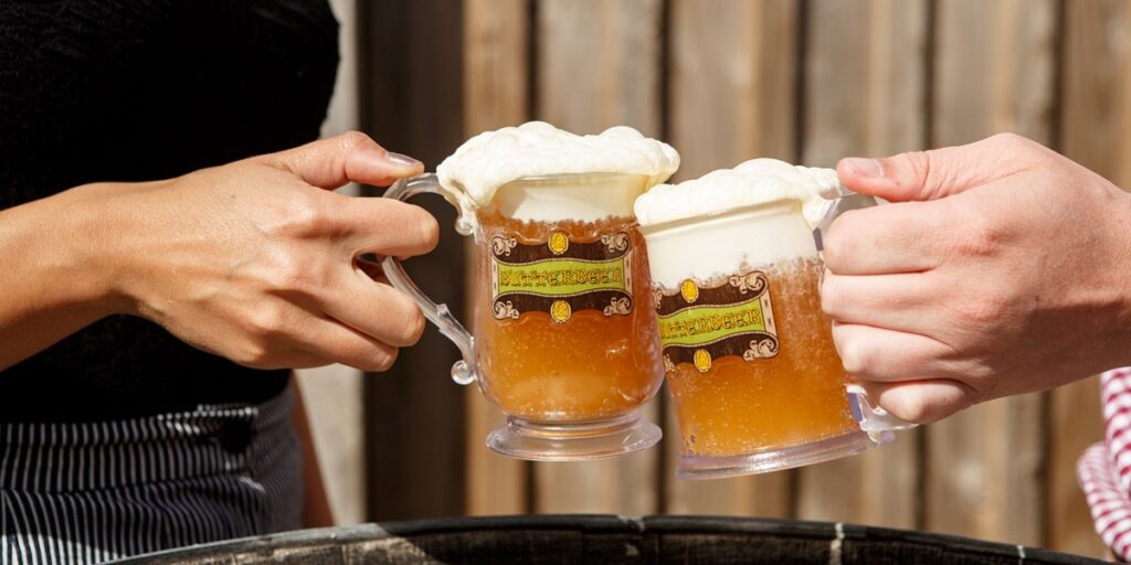 A shot of two people clinking their butterbeers together