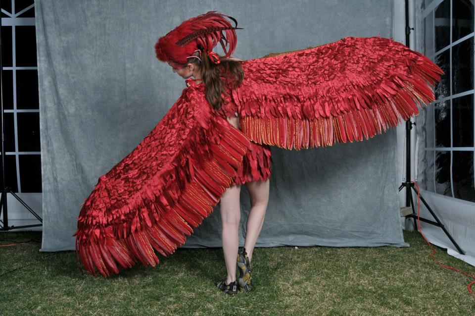 A woman stands in a gorgeous Fawkes costume, with a wingspan of 20 feet