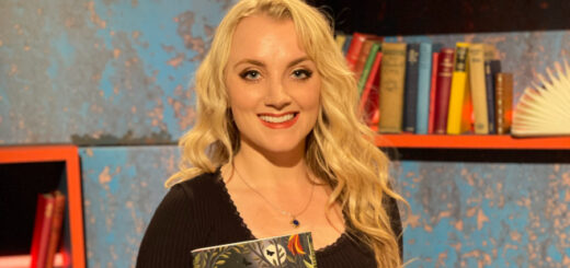 Evanna Lynch holding her new book "The Opposite of Butterfly Hunting"