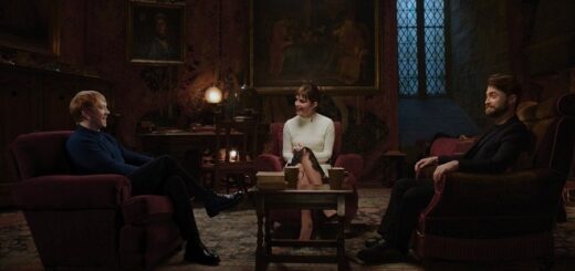 Rupert Grint, Emma Watson, and Daniel Radcliffe sit around a table in armchairs in the Gryffindor common room