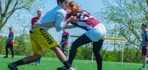 There is a female seeker who is trying to catch the snitch. There are three other players and one refferee in the background.