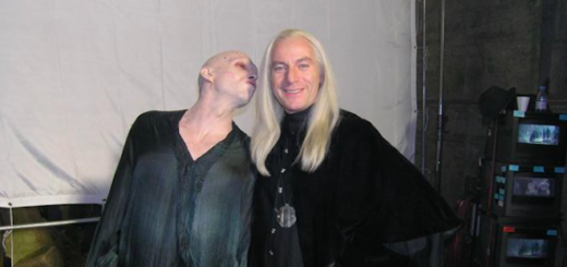 Jason Isaacs dressed in character as Lucius Malfoy and Ralph Fiennes dressed in character as Lord Voldermort pose for a photo.