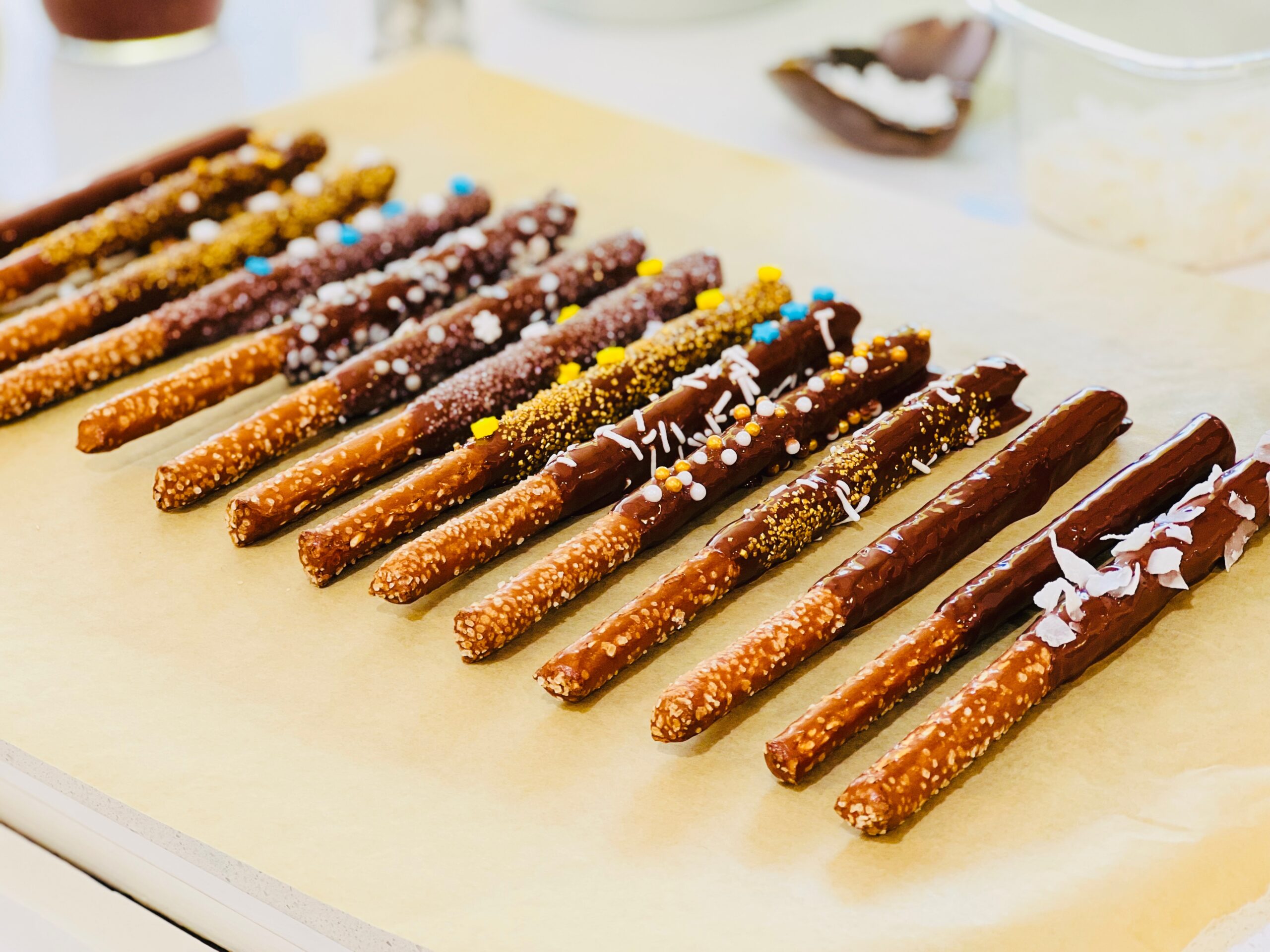 vegan chocolate wands lie atop a counter, in a pretty row