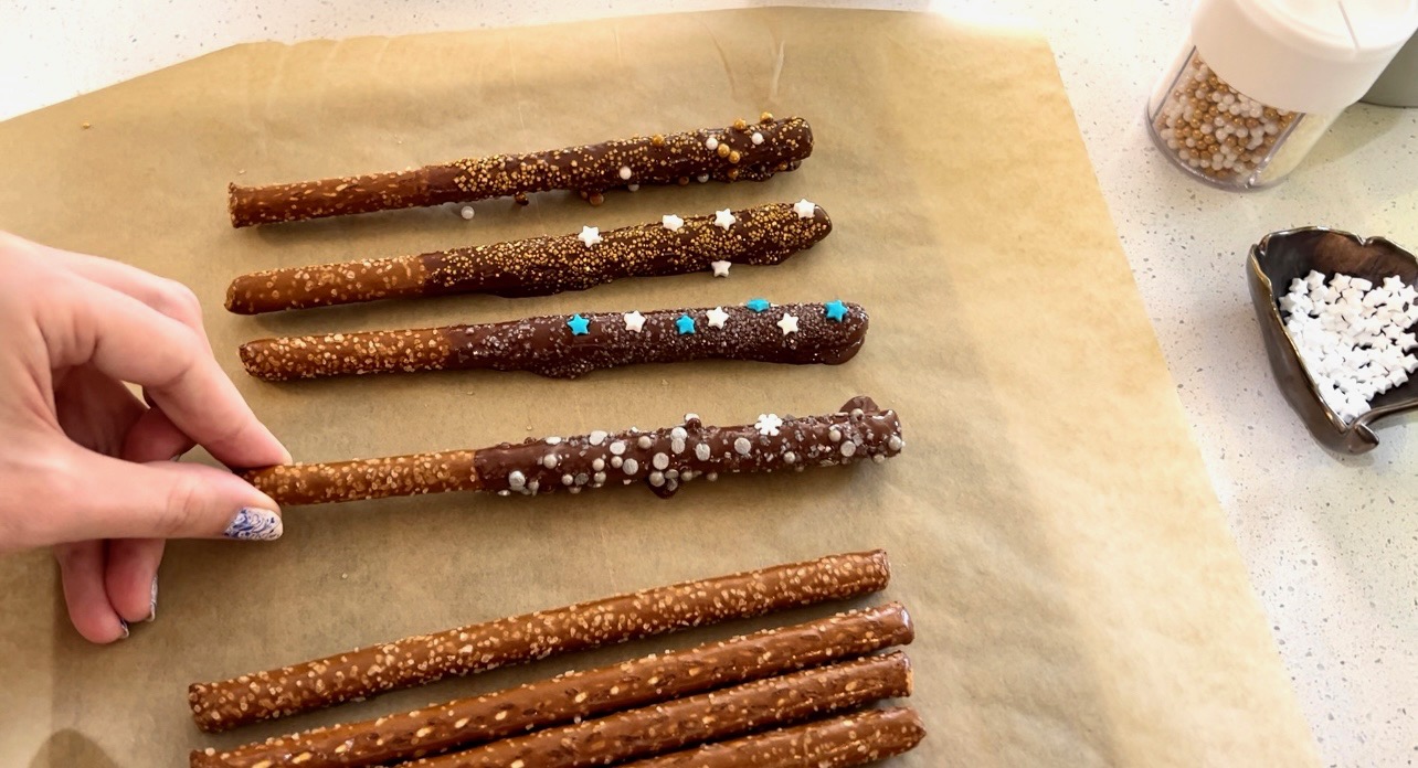 Freshly decorated chocolate wands are set onto wax paper