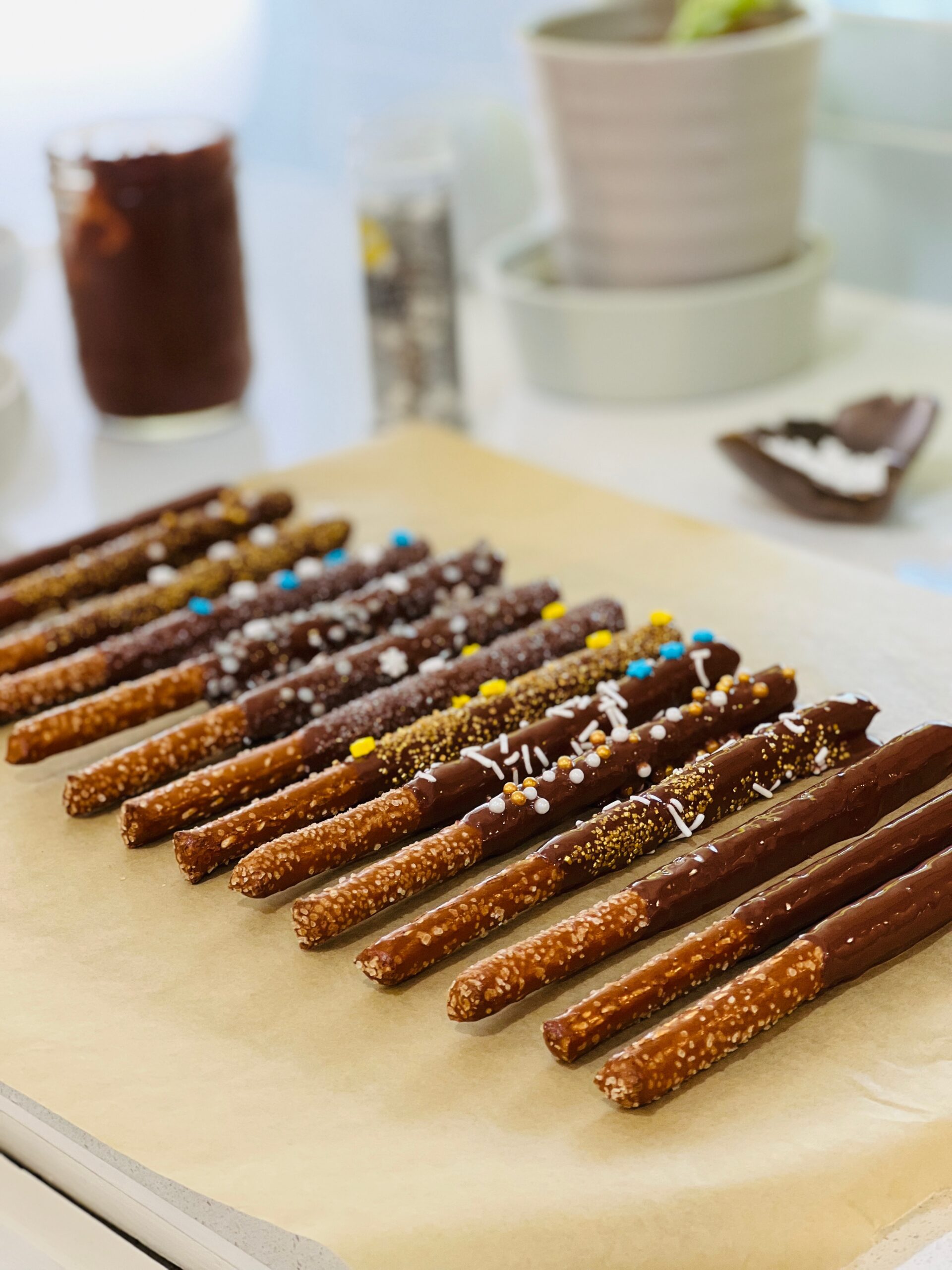 A tray of decorated vegan chocolate peanut butter pretzel wands