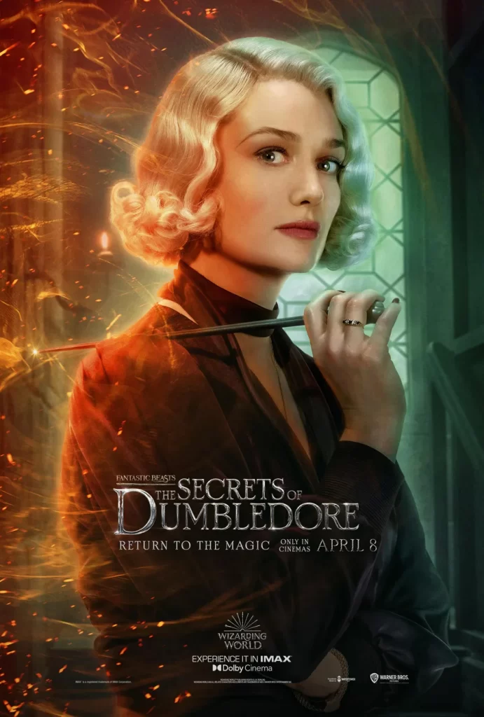 Queenie Goldstein character poster from Fantastic Beasts: The Secrets of Dumbledore. Queenie holds her wand pointed back at herself, and is lit by orage light on one side and green on the other.