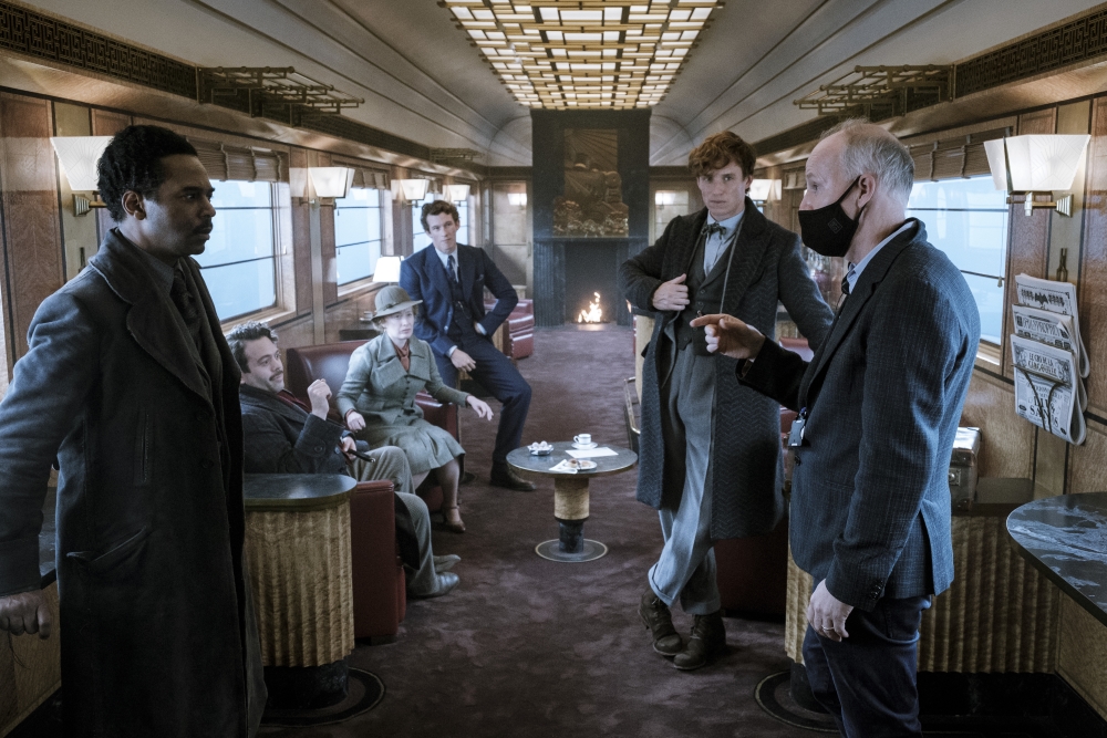 Director David Yates is shown directing the cast on the train set for “Fantastic Beasts: The Secrets of Dumbledore.”