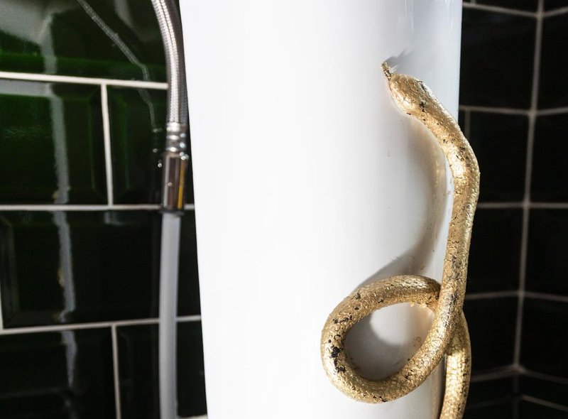 A photo of the "Harry Potter"-inspired Airbnb in Yorkshire shows the addition of a golden snake in the shower. (Credit: @101houseattheend on Instagram)