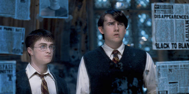Neville and Harry look in the mirror in the Room of Requirement.