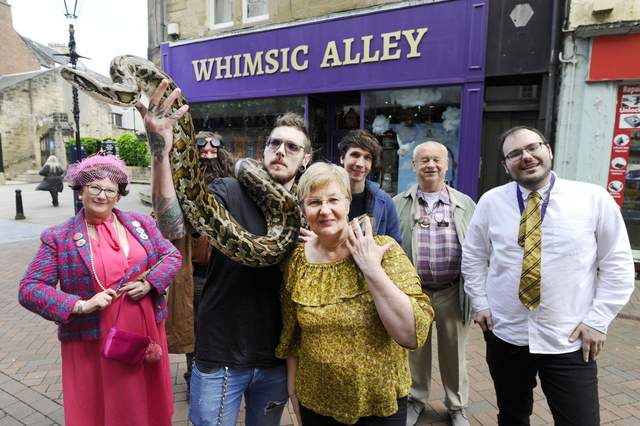 This is a photo of Doris and Leslie Lenaghen with the Burmese python at the opening of Whimsic Alley in Falkirk, Scotland.