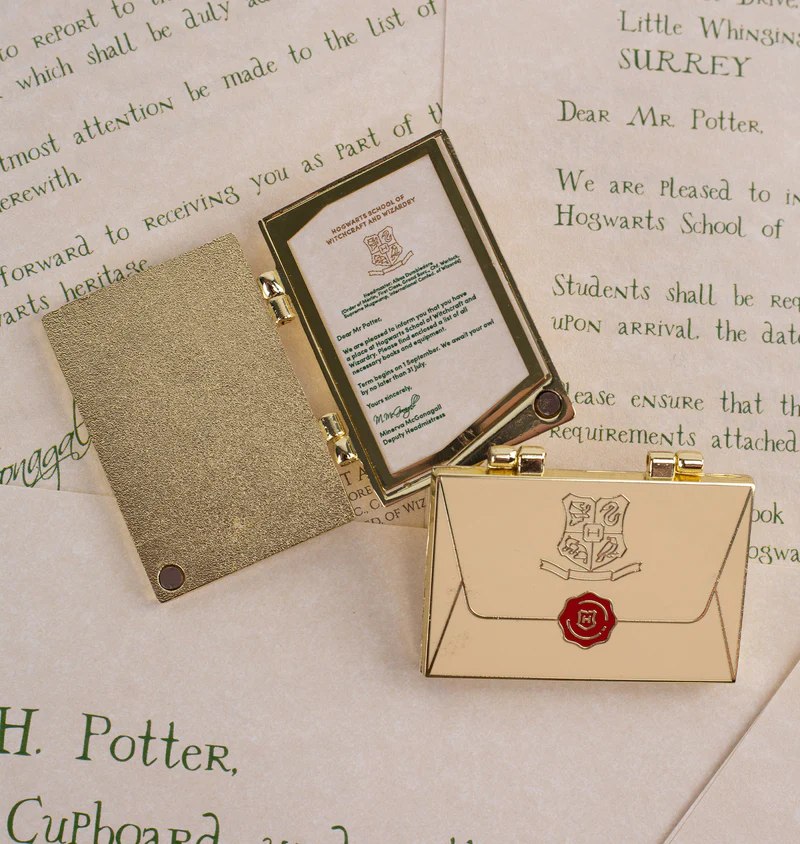 https://assets.mugglenet.com/wp-content/uploads/2022/07/Acceptance-Letter-Locket-Pin-HPFC.jpg