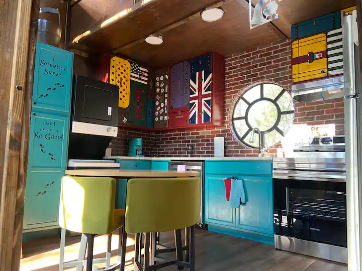 The colorful kitchen includes a small dining space and a fully functional washer/dryer.