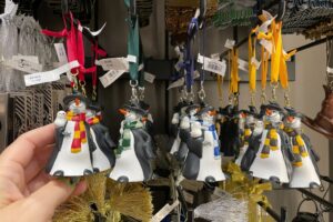 Four snowman ornaments, each dressed in Hogwarts House scarves, on sale at Universal Orlando Resort