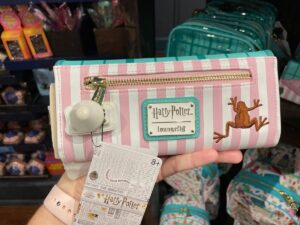 The back of the Honeydukes Loungefly wallet features pink and white stripes and a stitched chocolate frog.