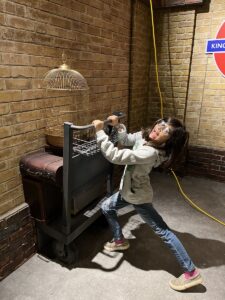 Trying to get onto Platform 9 3/4 at Two young children stand outside Privet Drive at Harry Potter: Magic at Play.