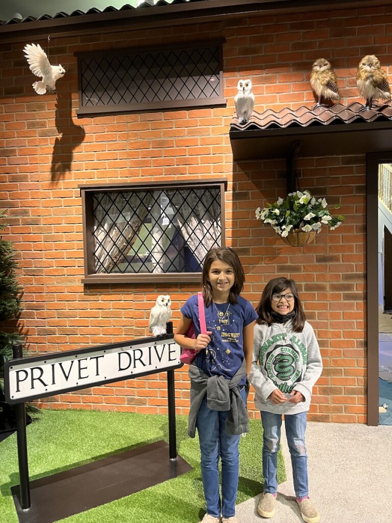 Two young children stand outside Privet Drive at Harry Potter: Magic at Play.
