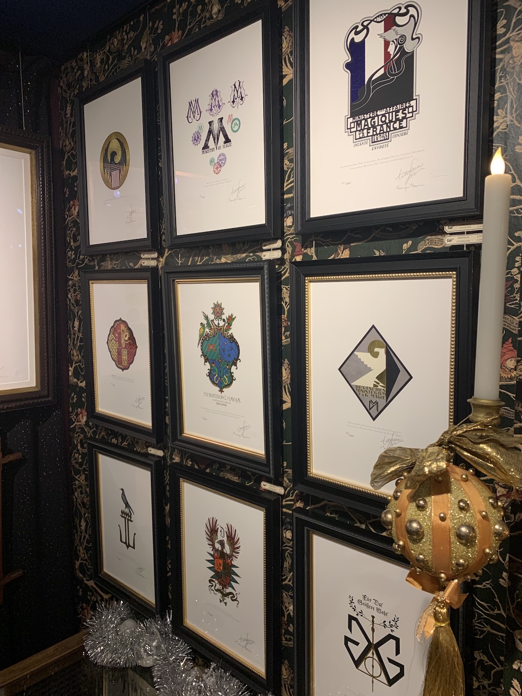 International Ministry of Magic crests line up uniformly on the wall at the House of MinaLima.