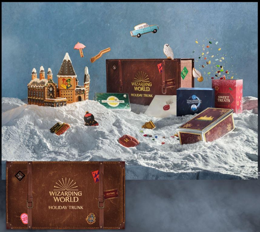 Contents of the Wizarding World Holiday Trunk displayed on a snowy surface, with the trunk itself overlaid at the bottom