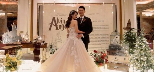 Newlyweds pose in front of "Potter"-themed decor