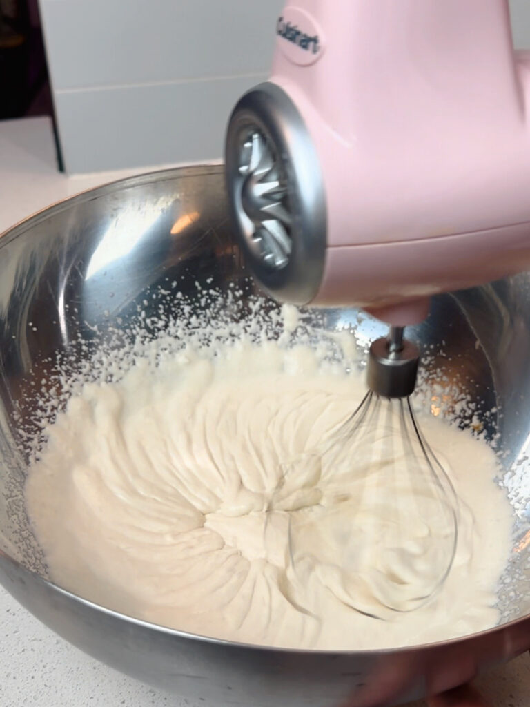 A hand mixer whips coconut into whipped cream