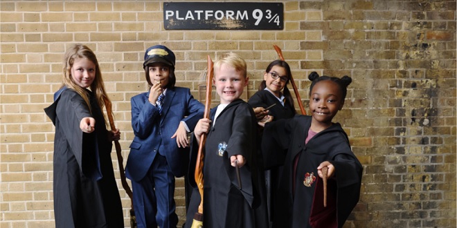 Five kids in front of Platform 9 3/4 sign at King's Cross