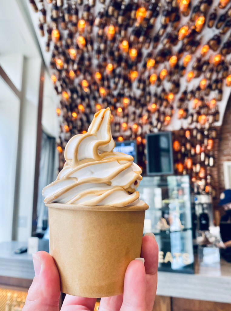 hand holding cup of butterbeer ice cream in butterbeer bar