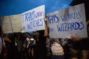 Photo from a protest showing support for trans witches and wizards