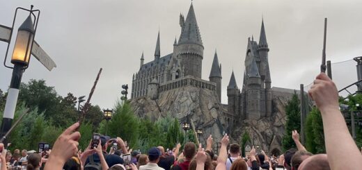 fans raise wands in front of Hogwarts Castle