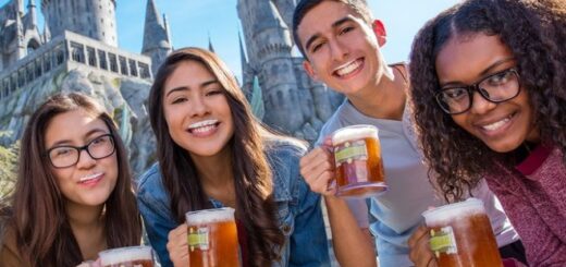 Fans smile and pose with tankards of Butterbeer and foam mustaches as Universal Studios Resort.