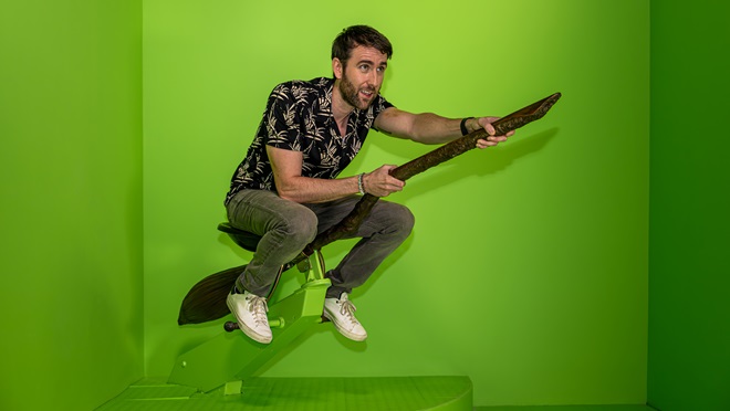 Matthew Lewis on broomstick surrounded by green screen