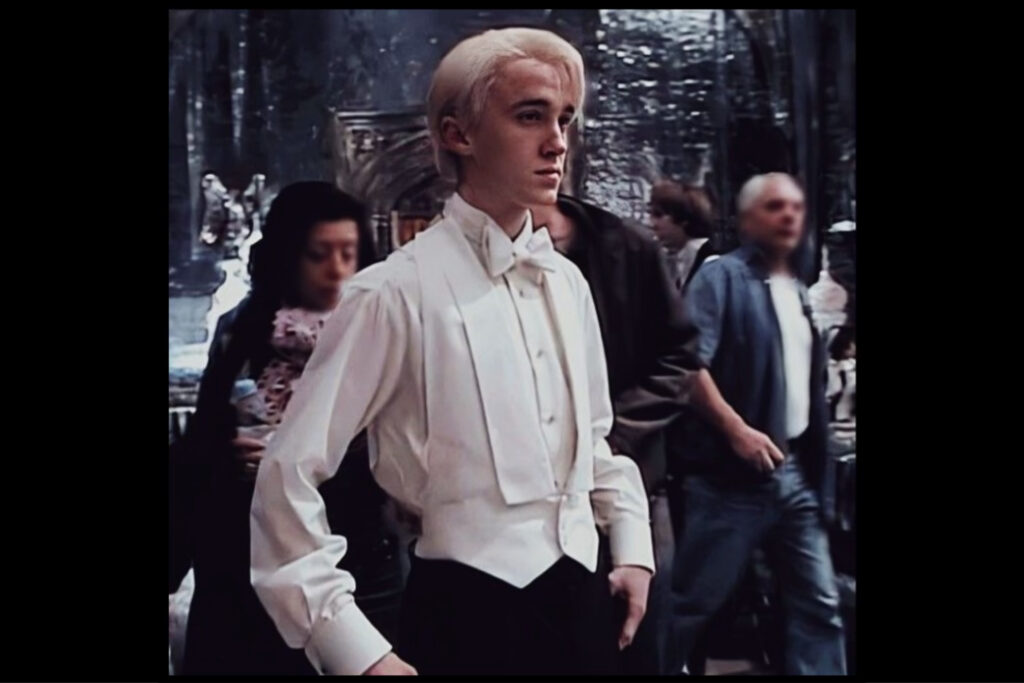 A behind-the-filming-scenes photo shows Tom Felton in a beautiful white tux at the Yule Ball on the set of Goblet of Fire