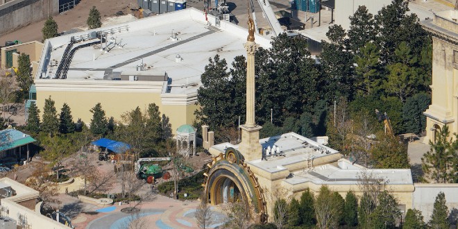 The gateway to the Wizarding World of Harry Potter Ministry of Magic park in Epic Universe features a portal inset with a Time-Turner and topped with a tall column bearing a hand with a wand.