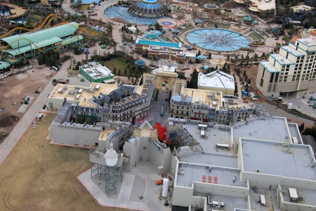 An aerial shot shows the five Parisian streets that make up the Ministry of magic section of Epic Universe. The Battle at the Ministry ride will be in a large building towards the back of the park.