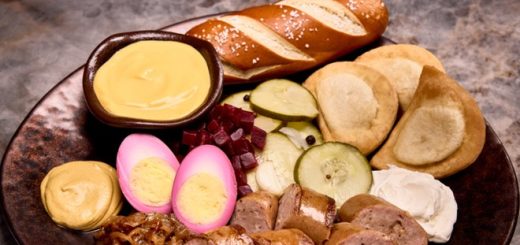 A photo of the Alchemists's Platter to be offered at Le Gobelet Noir, consisting of smoked sausage, potato and cheese pierogies, pickled eggs, marinated beets, savory caramelized onions, and a warm pretzel served with German mustard and cheese fondue.