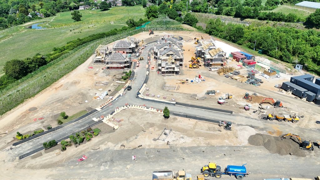 Buildings under construction at the end of a long driveway